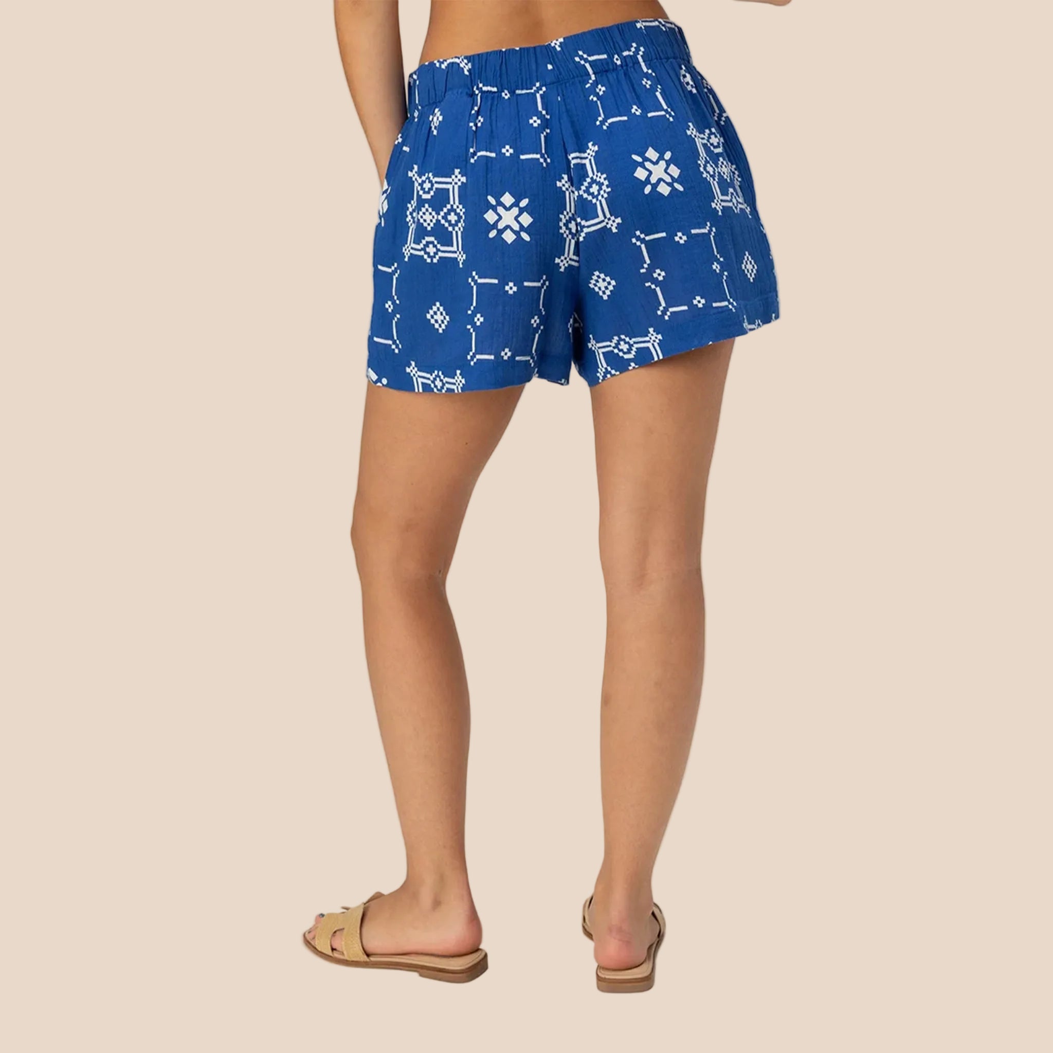 A dark blue pair of shorts with white tile shaped graphics. 