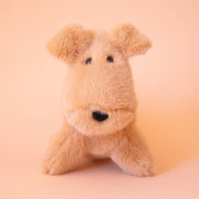 A tan dog shaped stuffed animal toy. 
