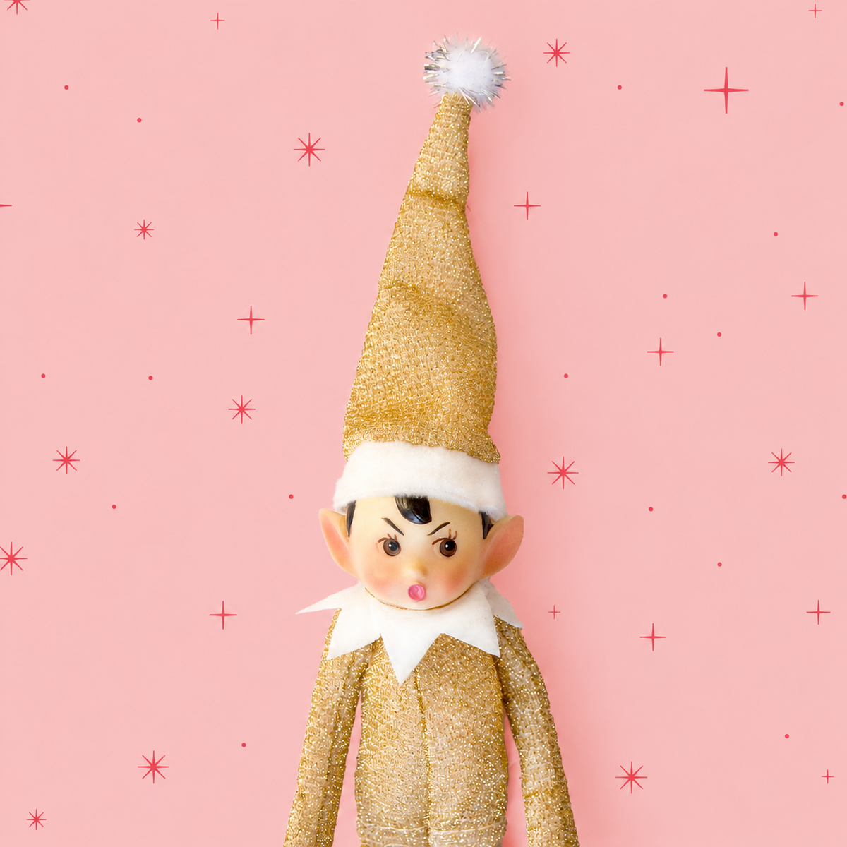 A gold sparkle elf shaped ornament with long limbs. 