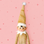 A gold sparkle elf shaped ornament with long limbs. 