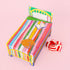 A multi colored box of candy with packaging the shape of a bed. 