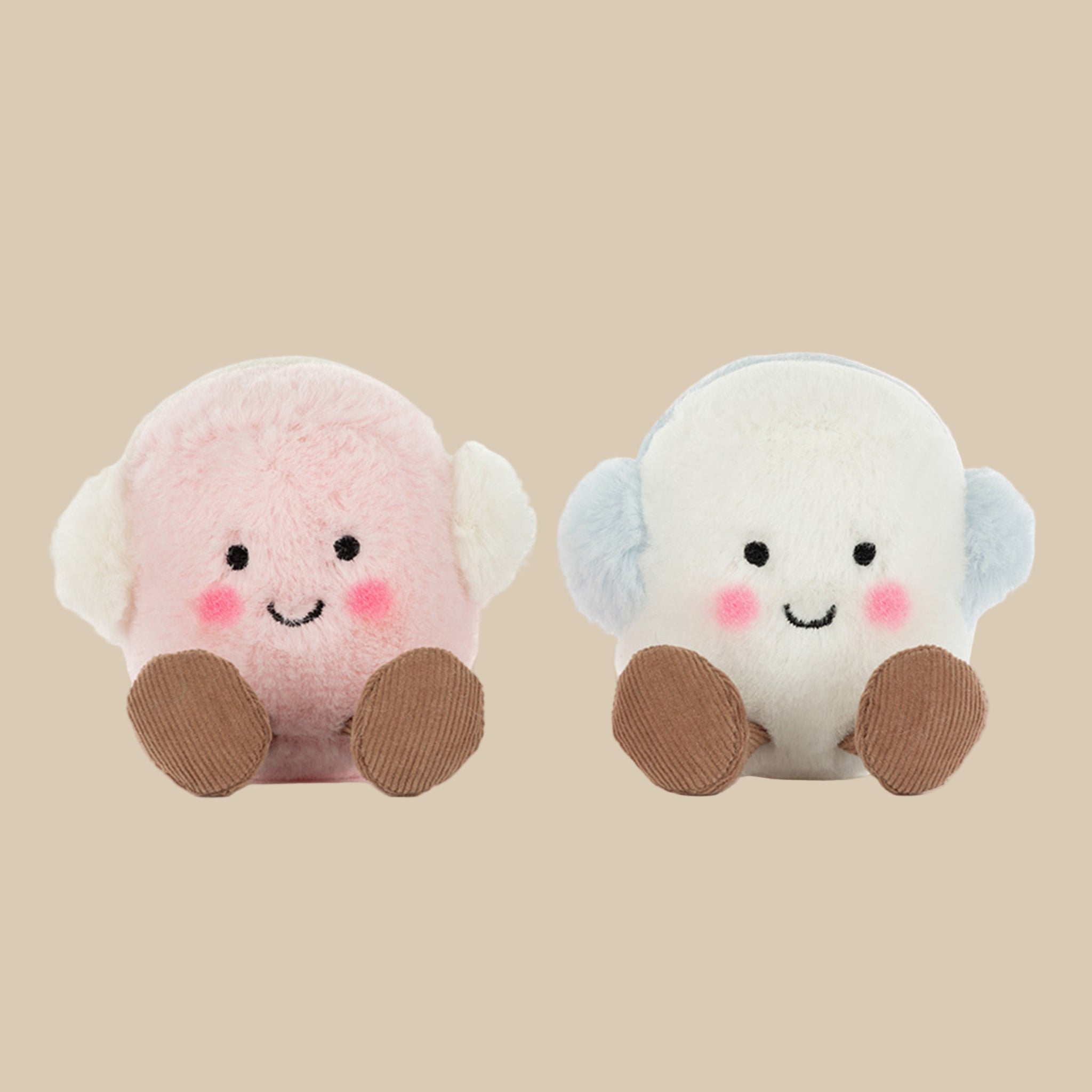A set of white and pink marshmallow shaped stuffed toy with smiling faces and brown feet and legs. 
