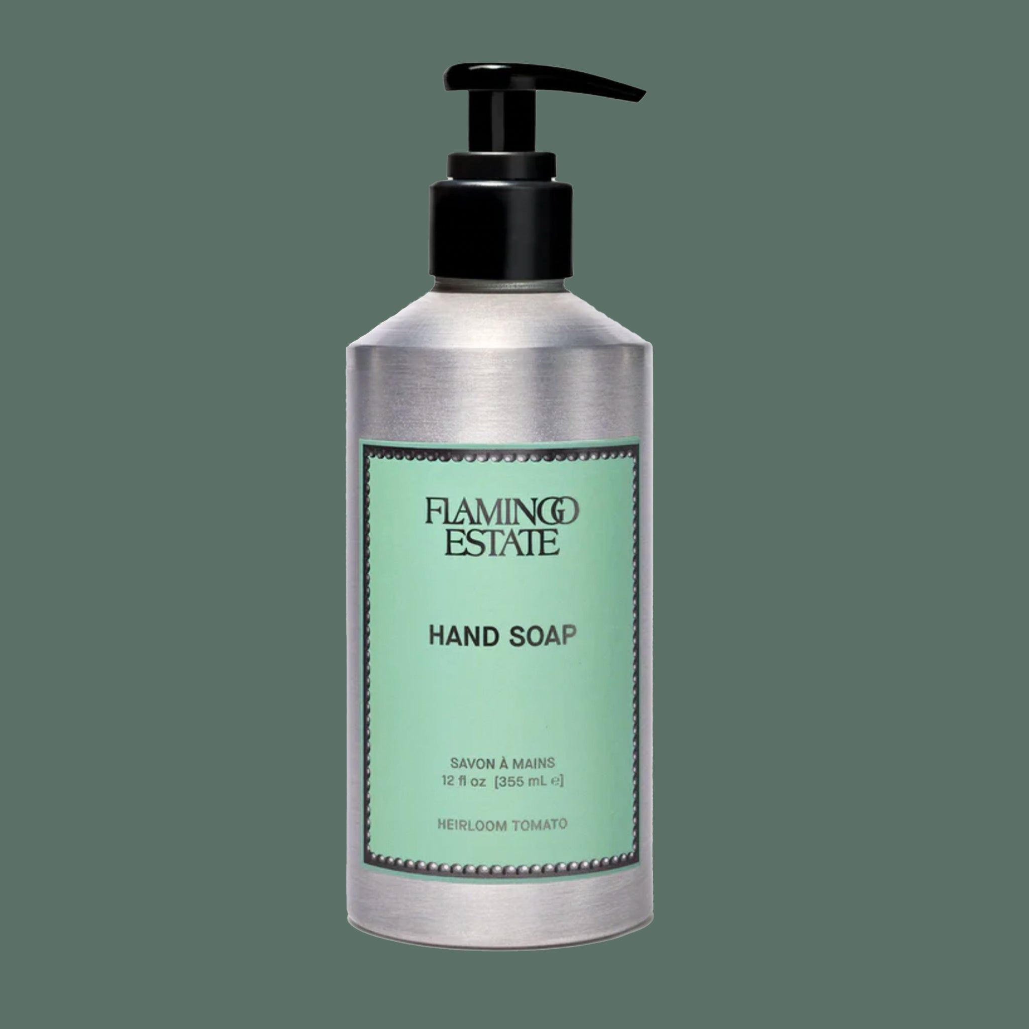 A silver bottle of soap with a light teal label with black text that reads, 'Flamingo Estate Hand Soap". 