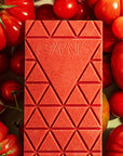 A chocolate bar with a tomato packaging and text that reads, 'Compartes Tomato Chocolate'. 