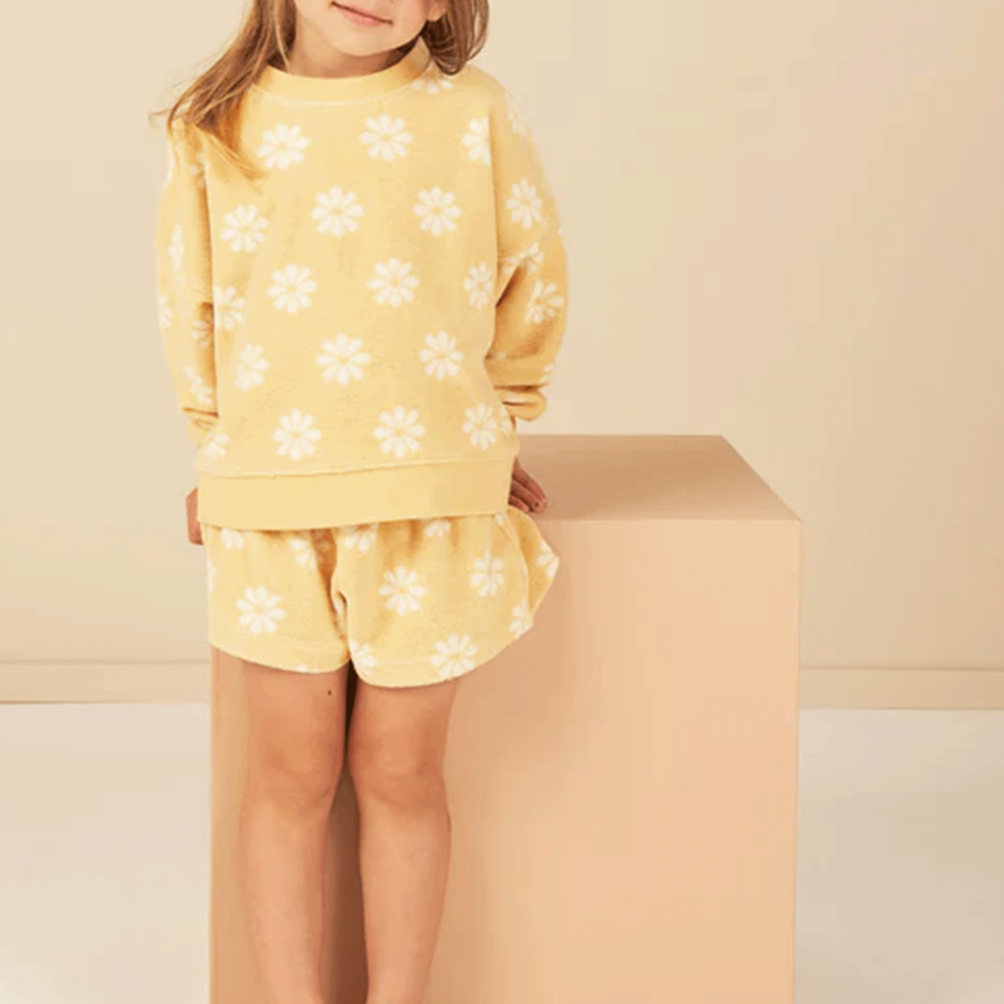 A yellow and white daisy printed pullover sweatshirt. Accessories and shorts not included.