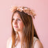 A flower crown made of muted mauve dried florals and a adjustable tie in the back.