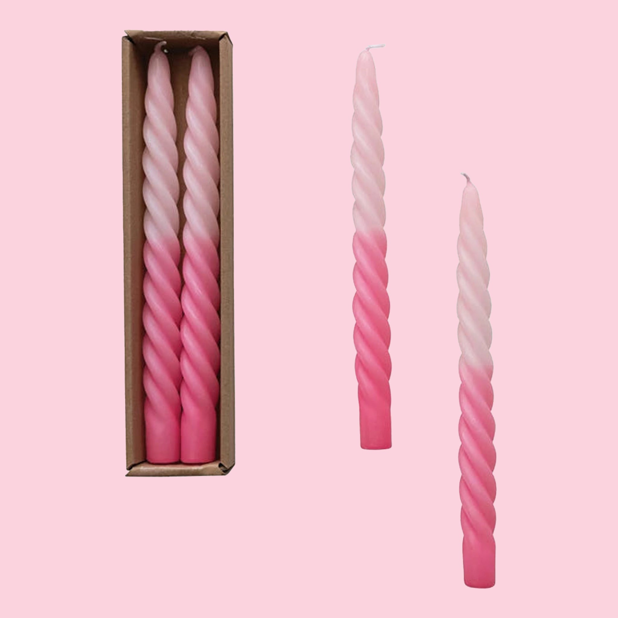 On a light pink background is a set of pink twisted taper candles with an ombre color gradient. 