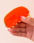 A two-toned rounded claw clip in shades of orange.