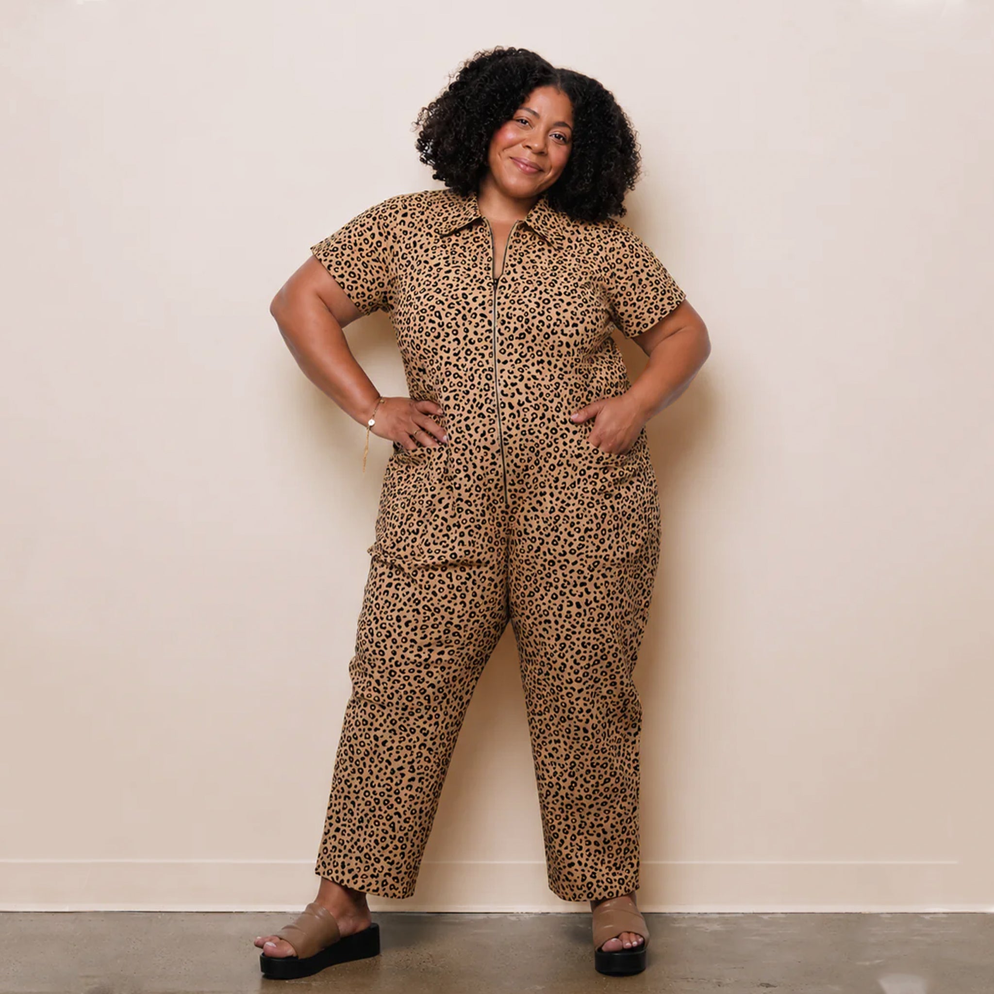 A leopard print utility jumpsuit with short sleeves, a collar and a zipper down the front. 