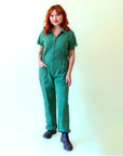 A green short sleeve jumpsuit with a zipper up the front. 
