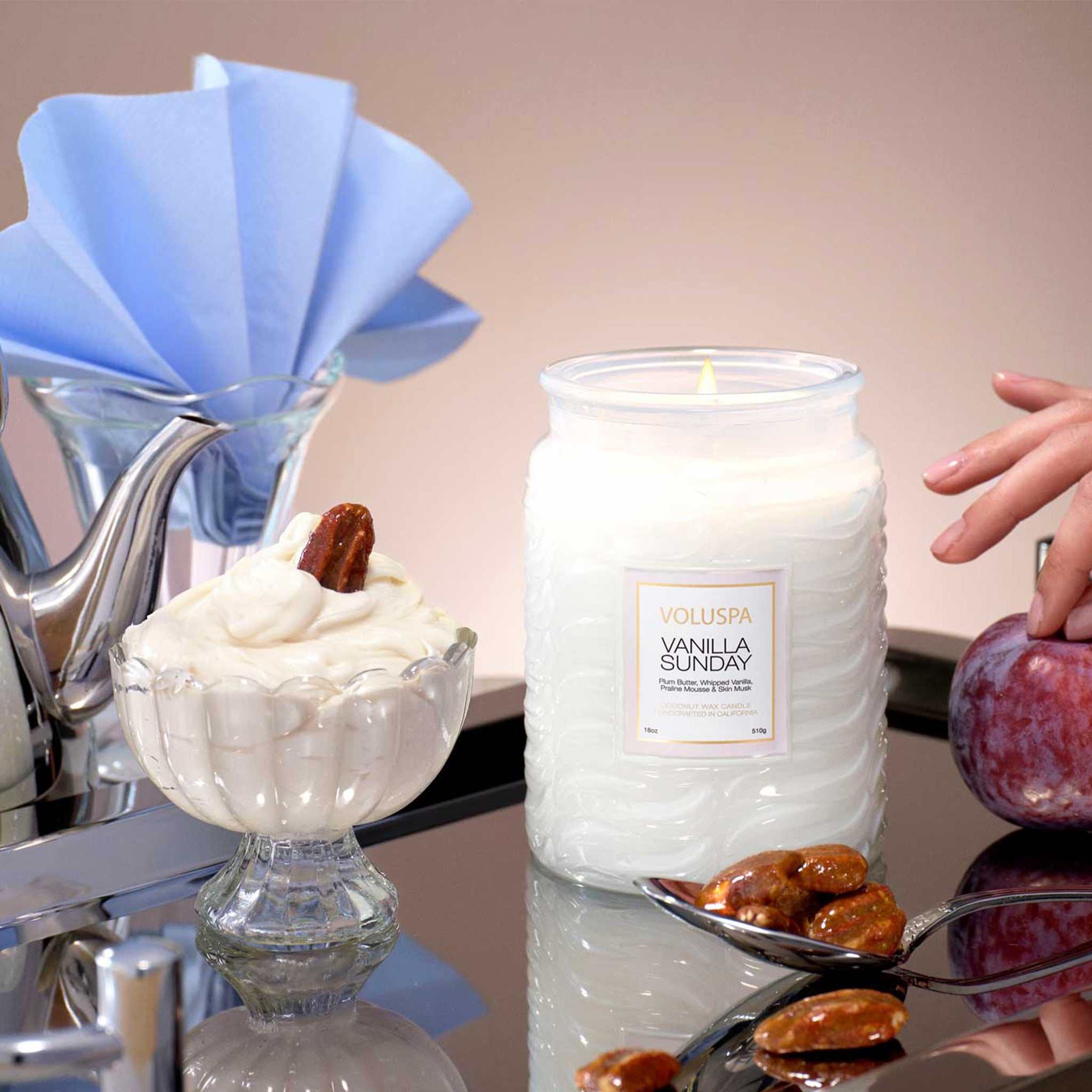 A white large jar glass candle with a rectangle label that reads, "Voluspa Vanilla Sunday". 