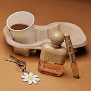 A brown and light pink bottle of perfume with text that reads, 'Boy Smells Vanilla Era'. 