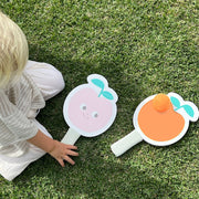 Two peach shaped paddle beach velcro bat toys with a orange ball. 