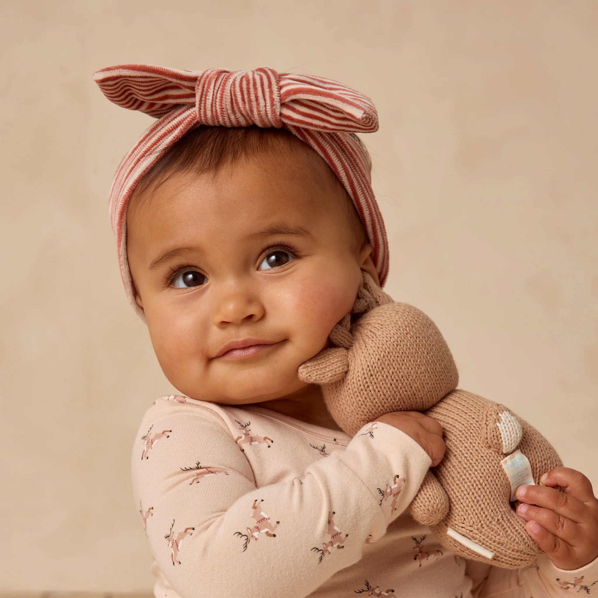 A baby wearing a red and white striped bow headband. 
