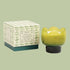A green tulip shaped glass candle. 