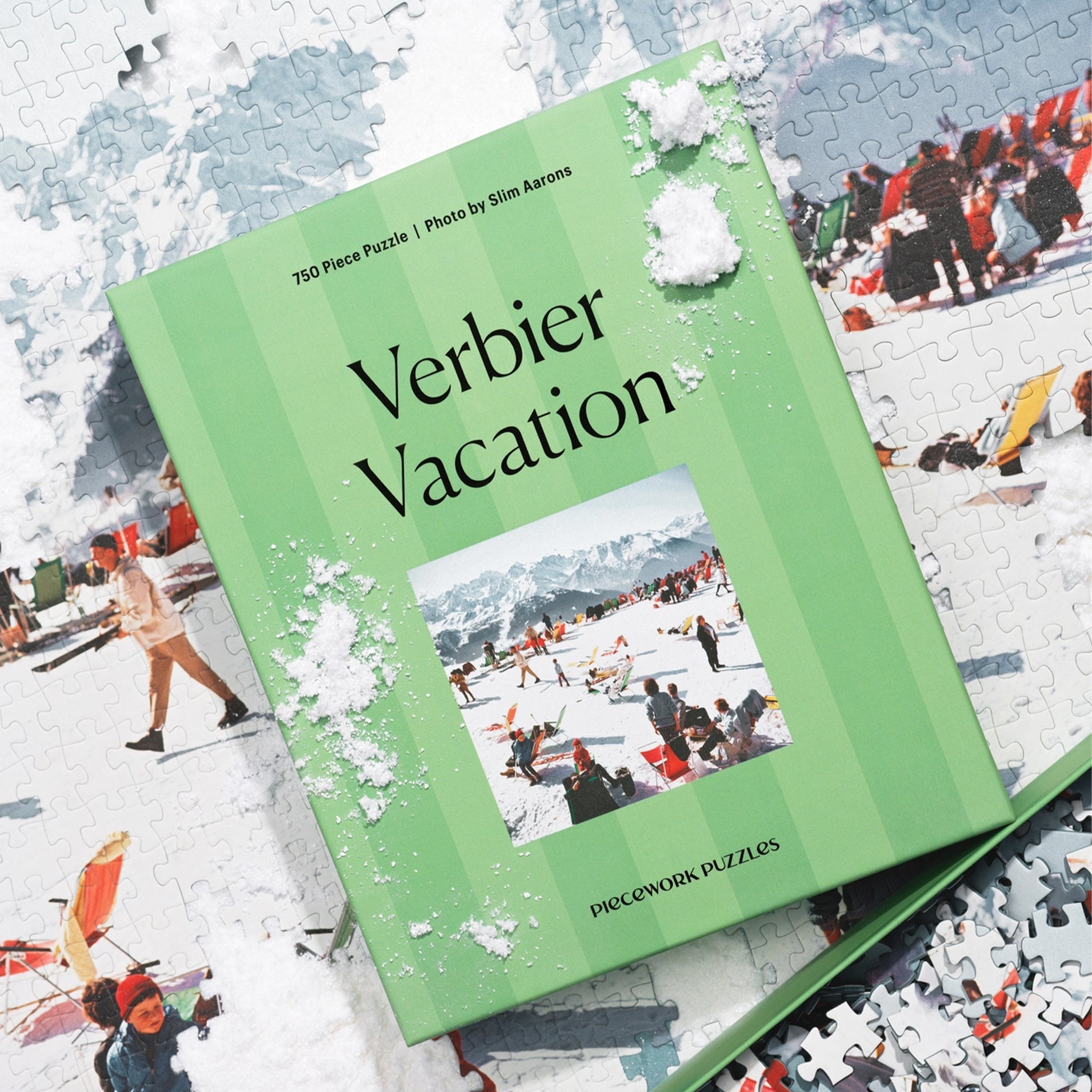 &quot;Verbier Vacation Piecework Puzzle&quot;. A green striped puzzle box with a photo of a snowy ski slopes image. 