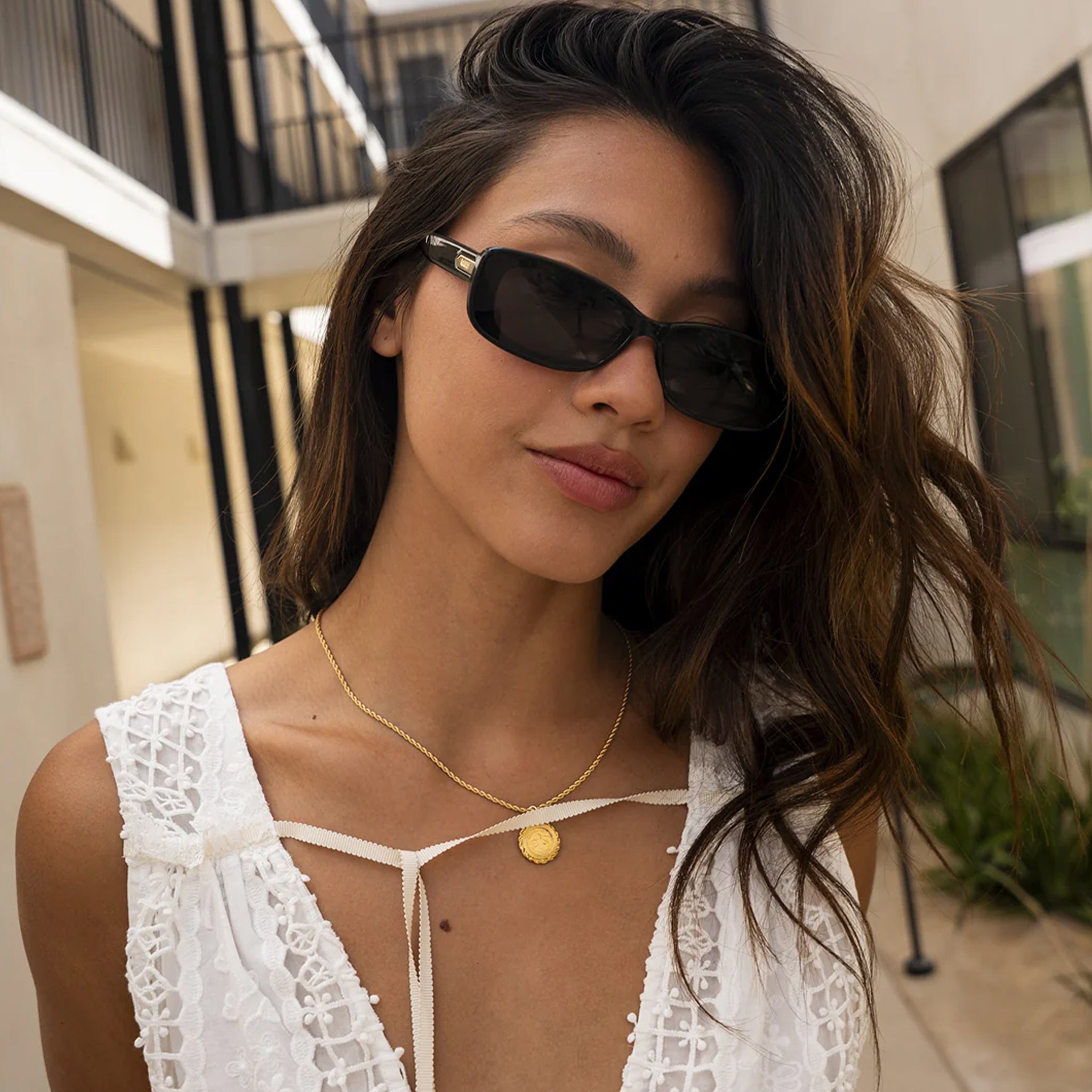 A black rectangle shaped sunglass with dark grey lenses. 