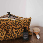 A brown leopard print canvas cosmetic pouch. 