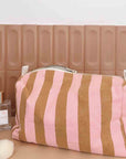 A pink and brownish orange striped canvas cosmetics bag. 