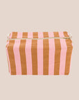 A pink and brownish orange striped canvas cosmetics bag. 