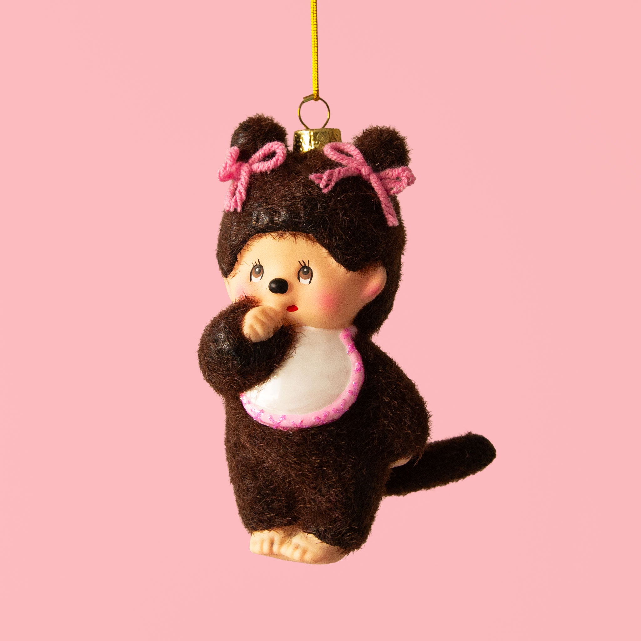 A vintage monkey doll ornament with pink bows. 