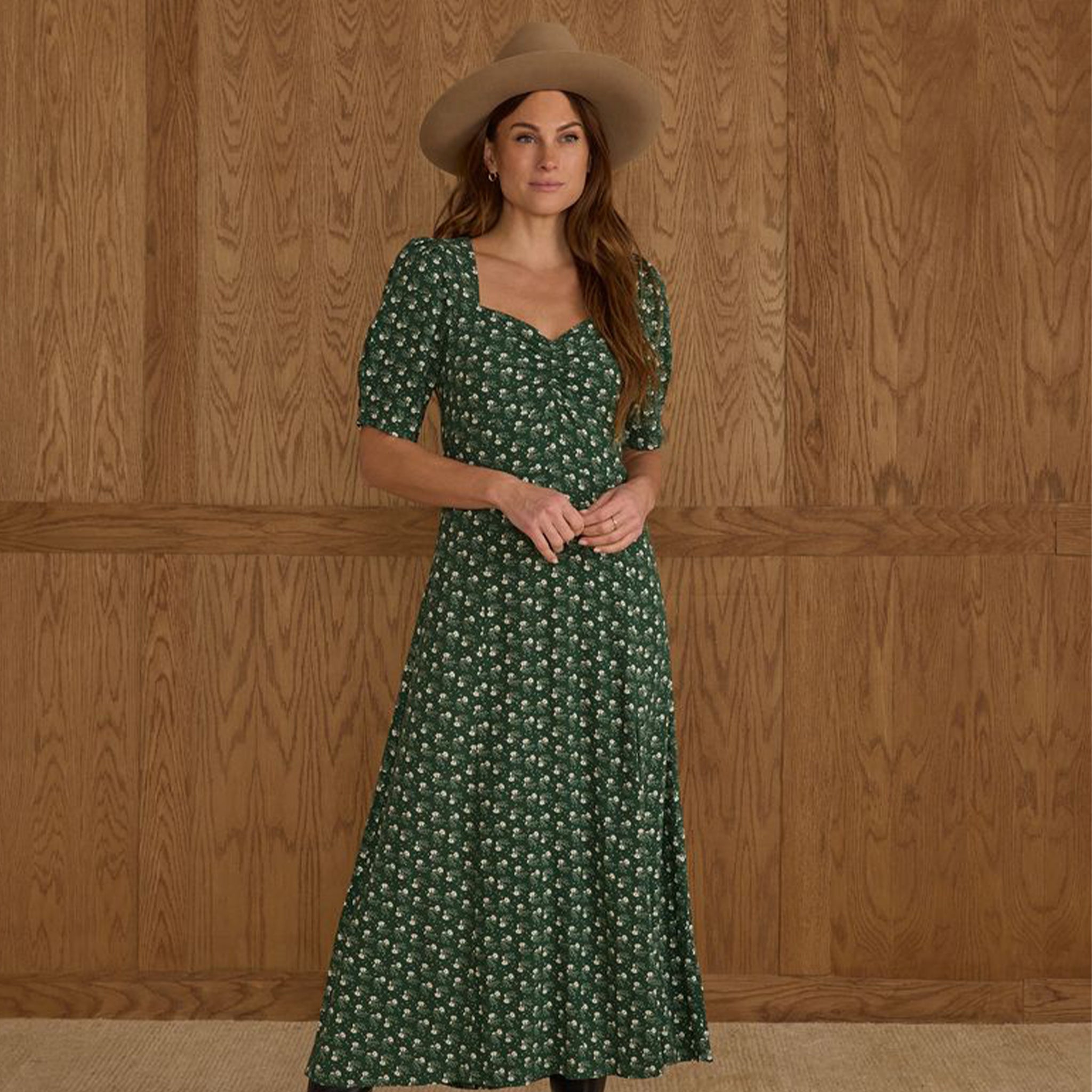 A green dress with a white floral print and puff sleeves. 