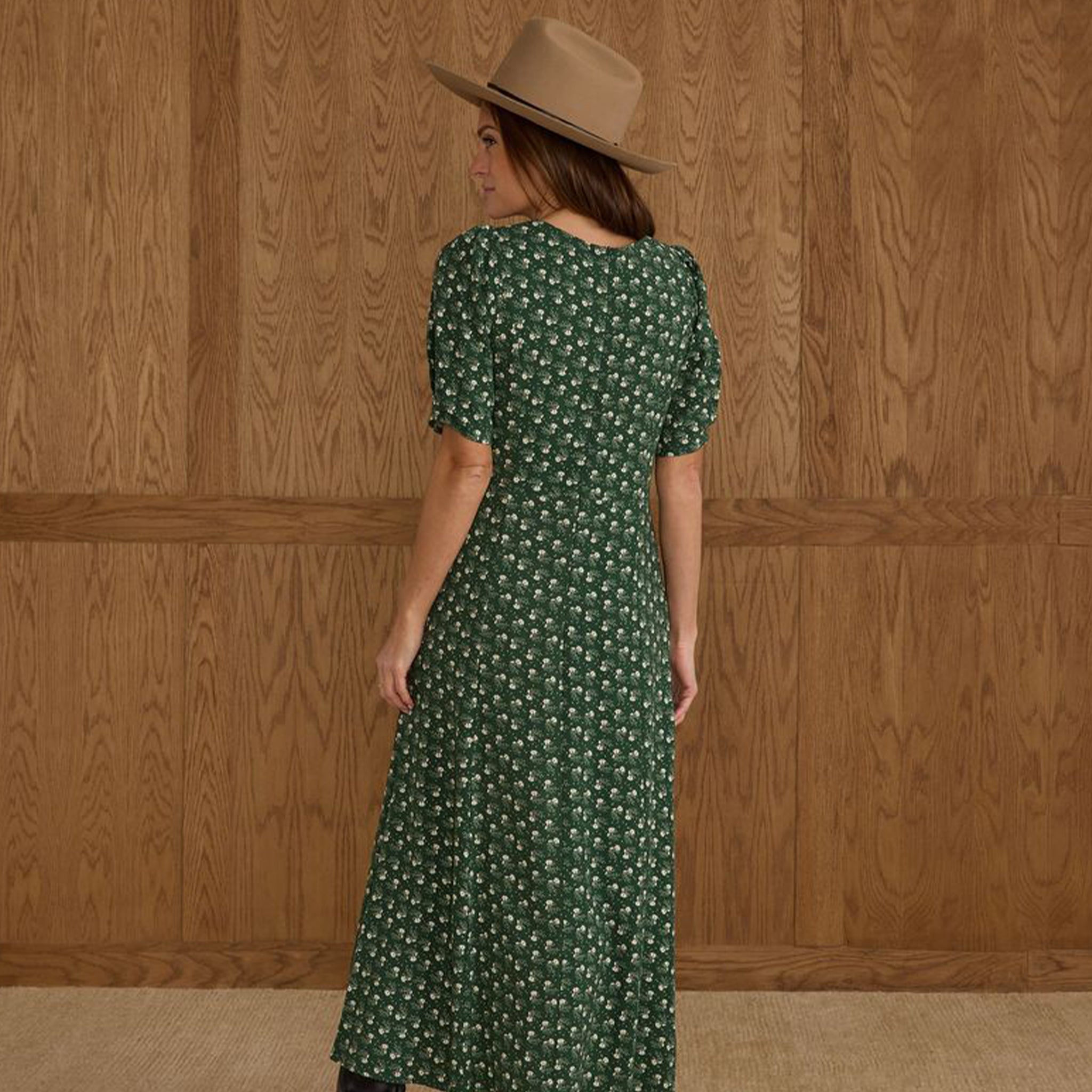 A green dress with a white floral print and puff sleeves. 