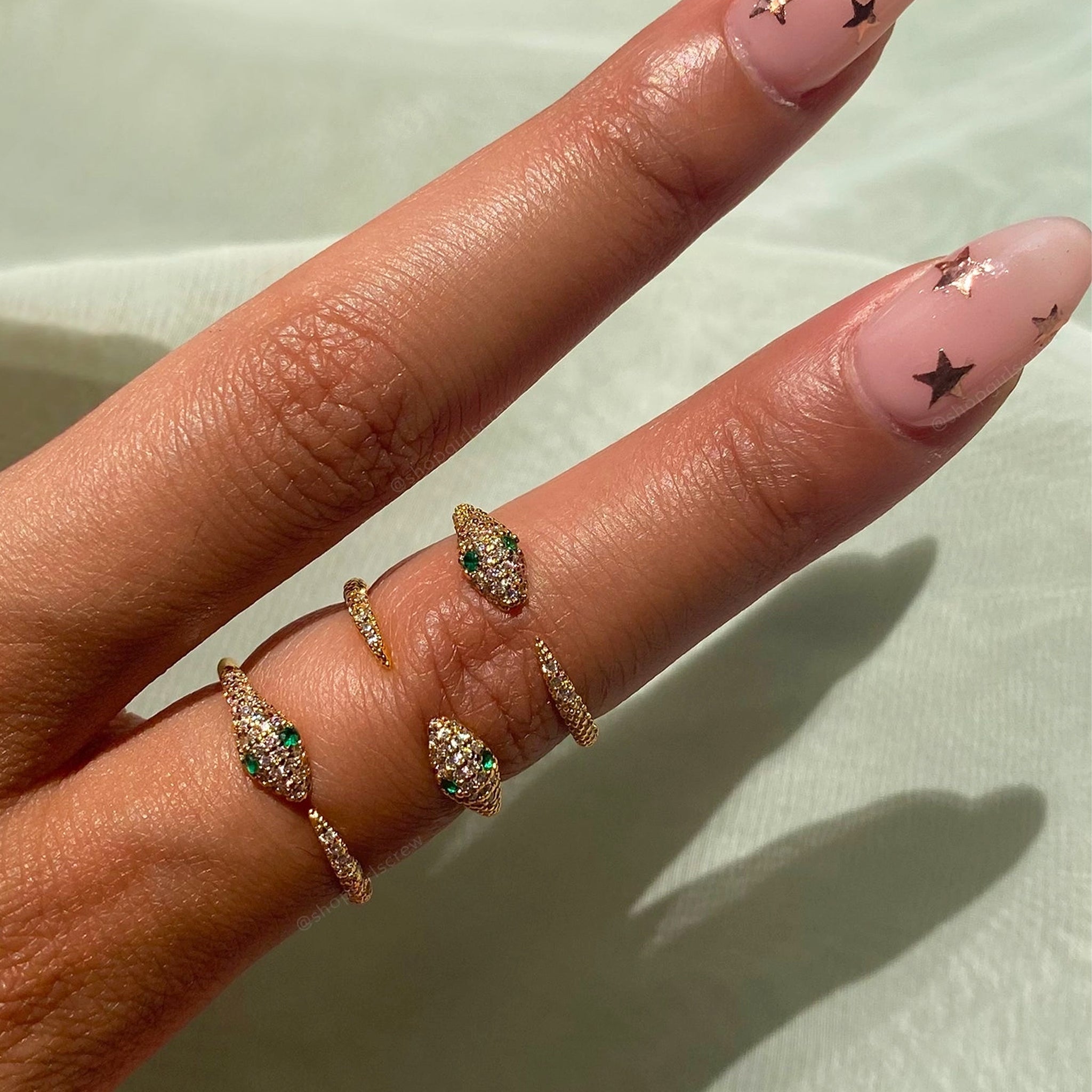 A snake design ring with green cz stones for eyes.