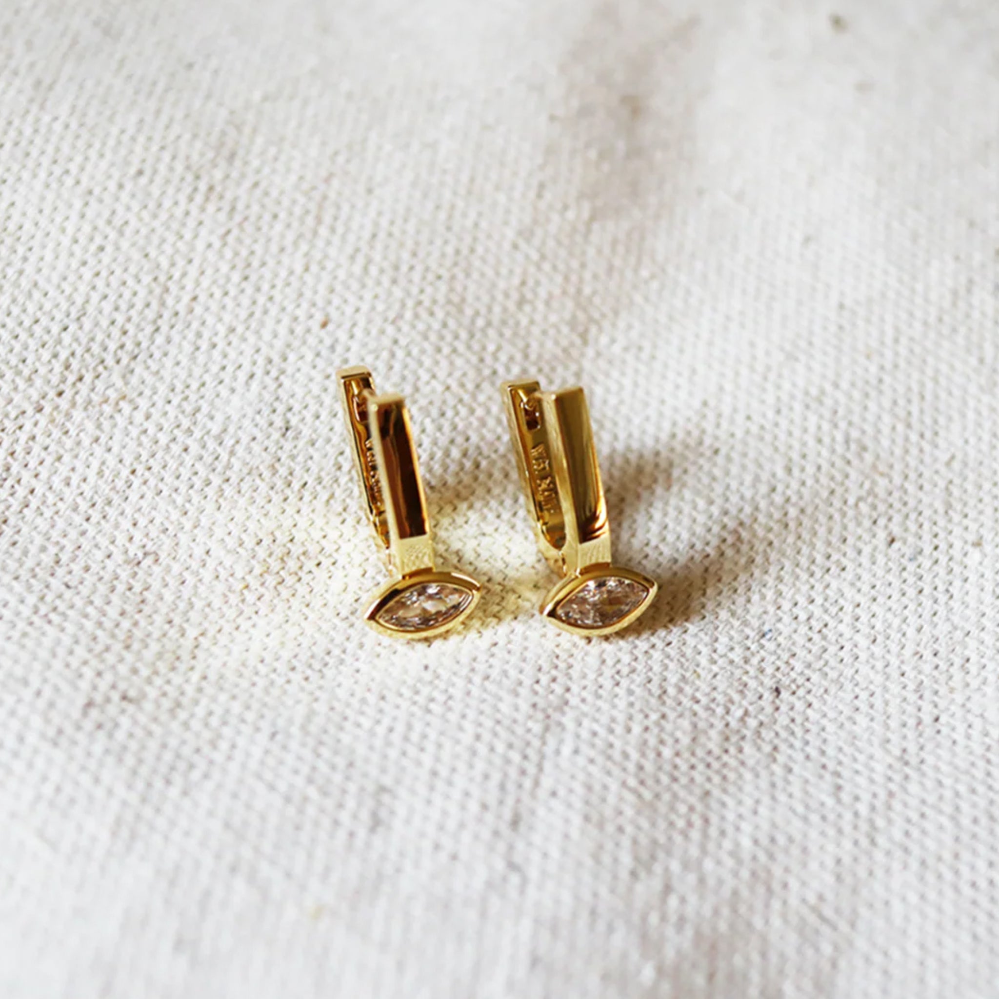 A pair of gold hoops with a marquise shaped cz stone in the center off the bottom. 