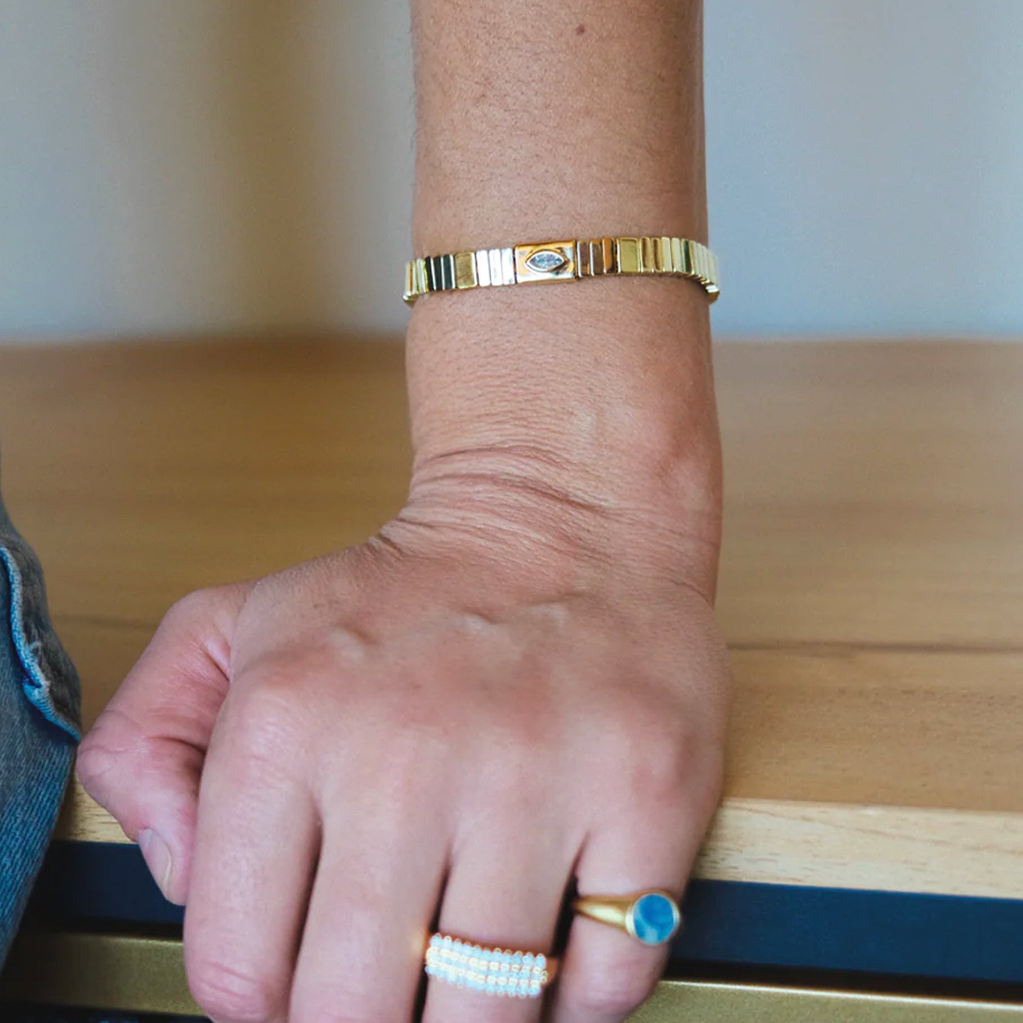 A gold beaded stretch bracelet with a marquise shaped cz in the center. 