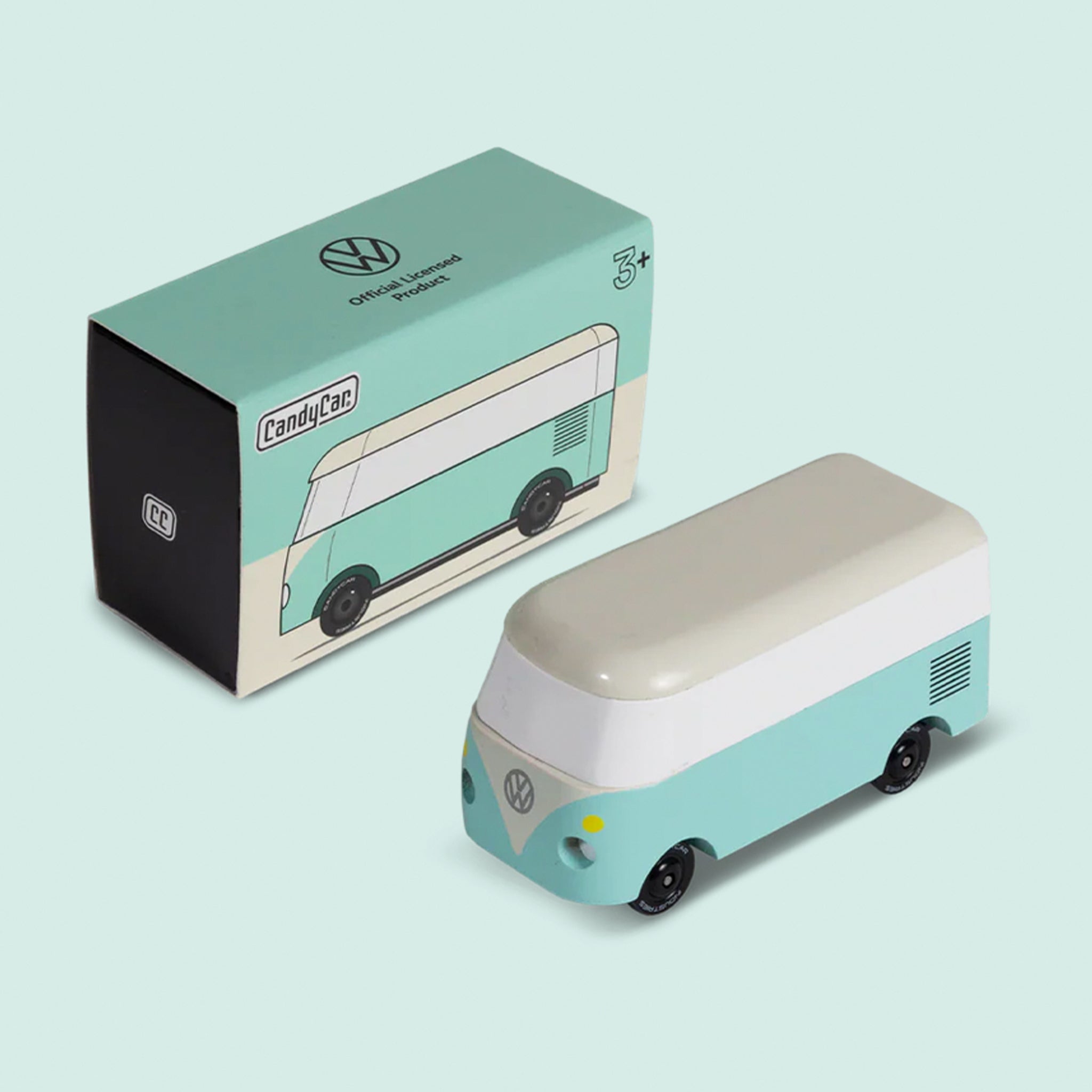 A mini wooden VW bus toy with a teal and white design. 