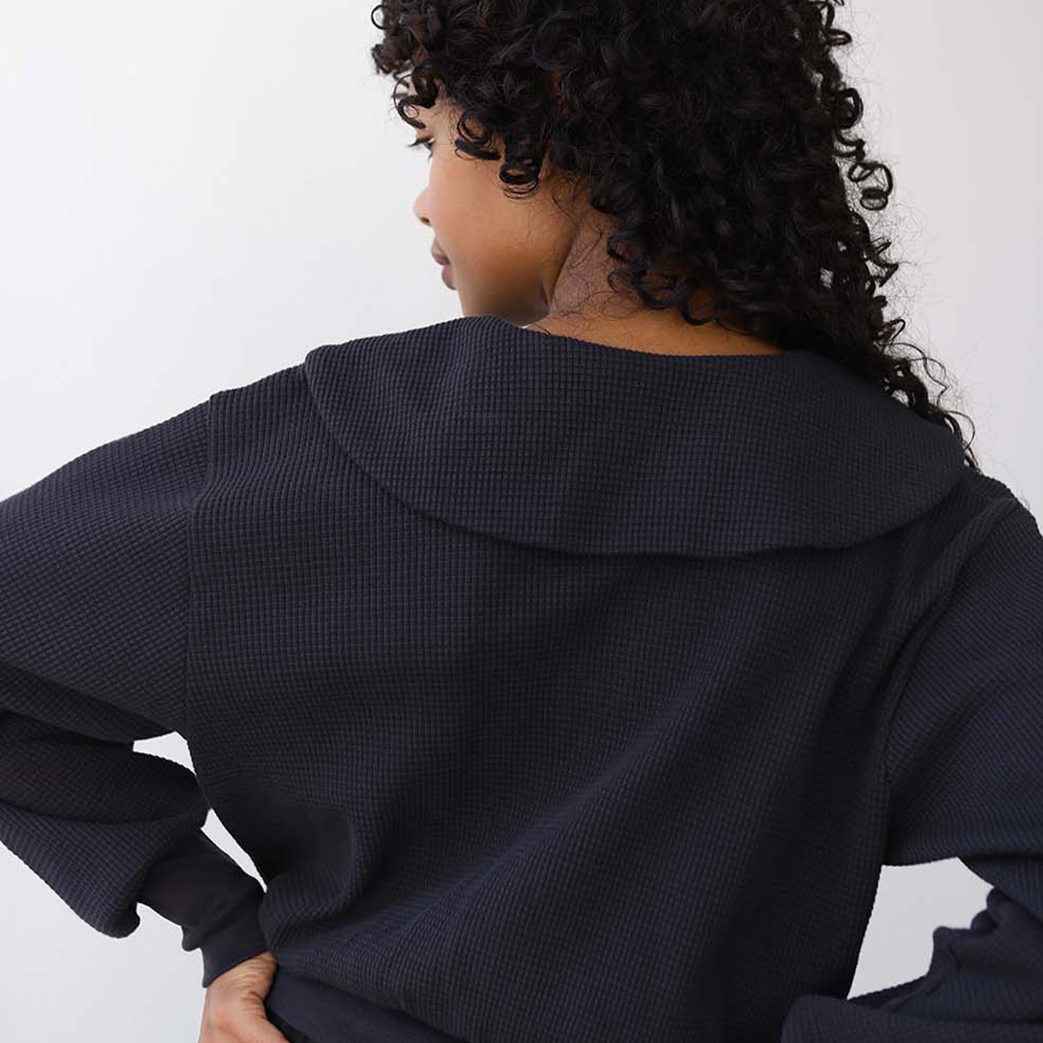 A black waffle knit button up cardigan with a collar. 