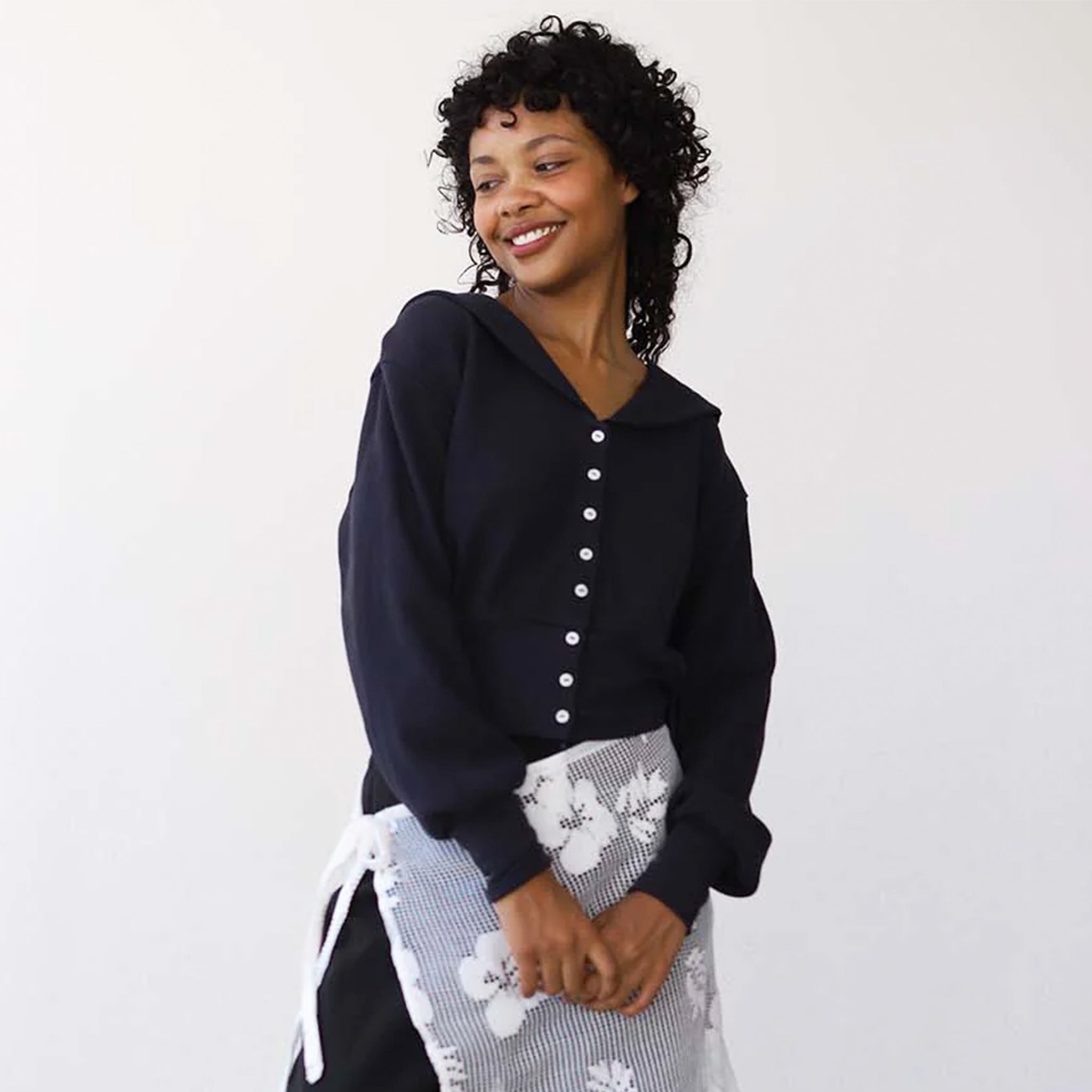 A black waffle knit button up cardigan with a collar. 