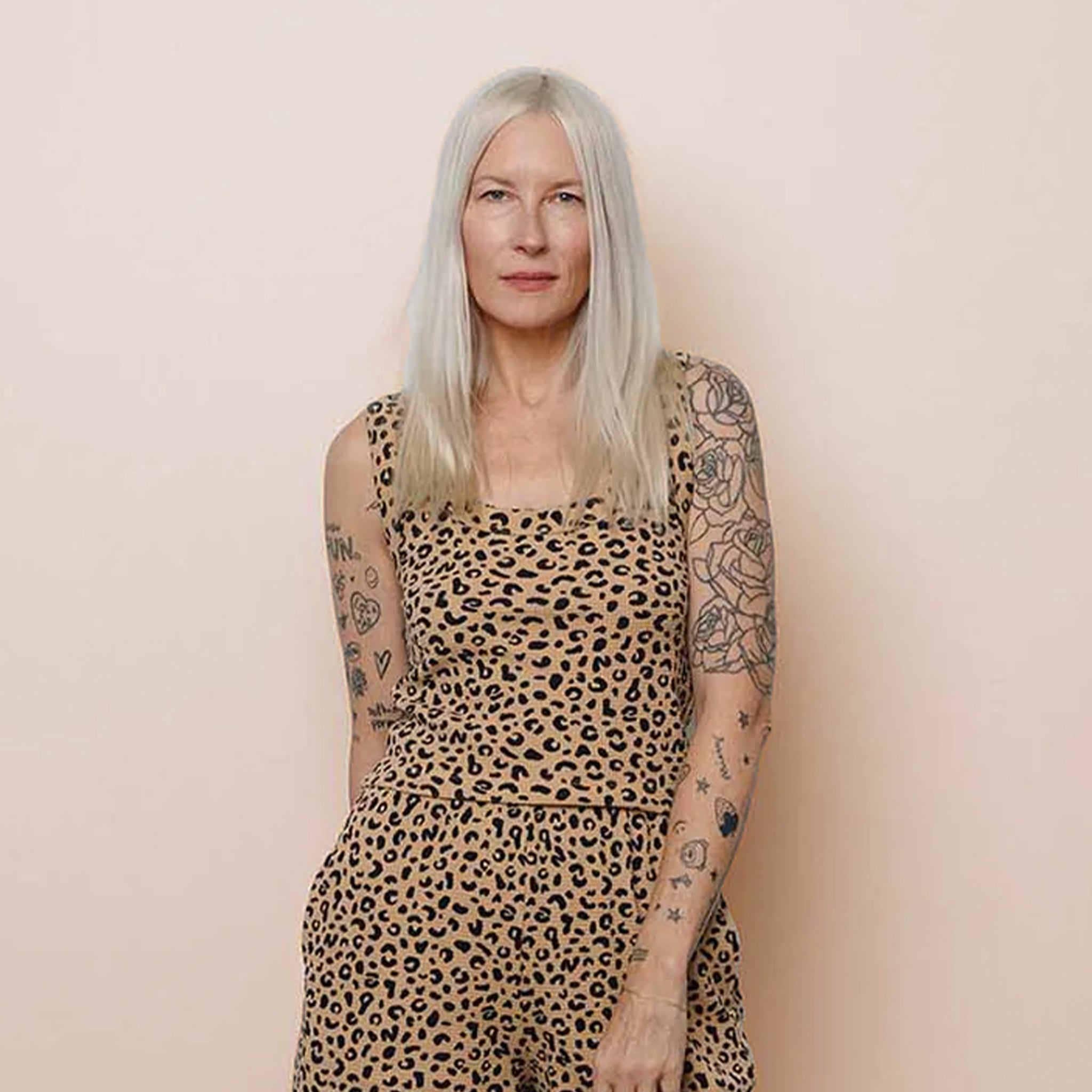 Woman wearing a leopard print tank top against a beige background