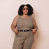 Woman wearing a leopard print tank top with a belt against a beige background