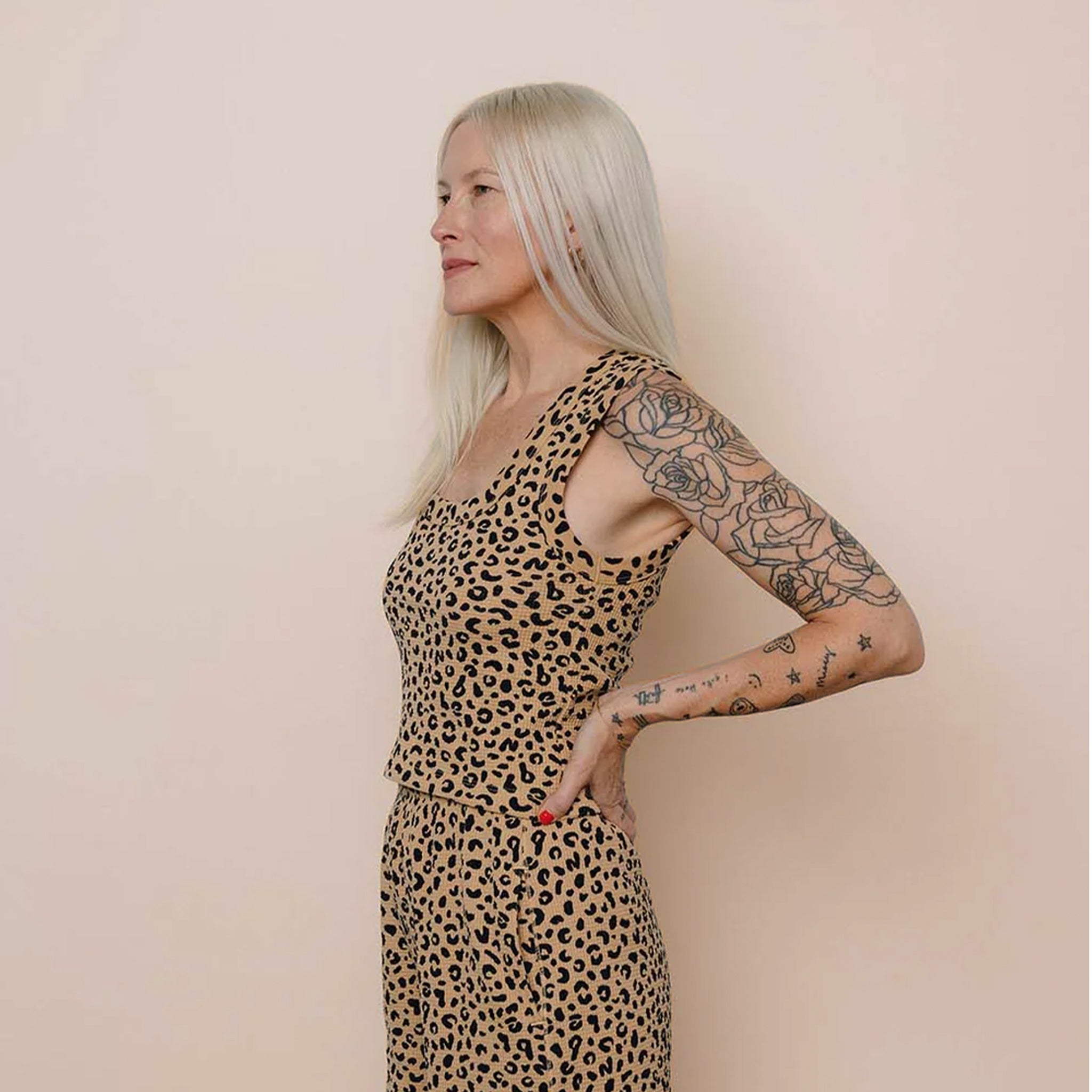 Woman wearing a leopard print tank top against a beige background