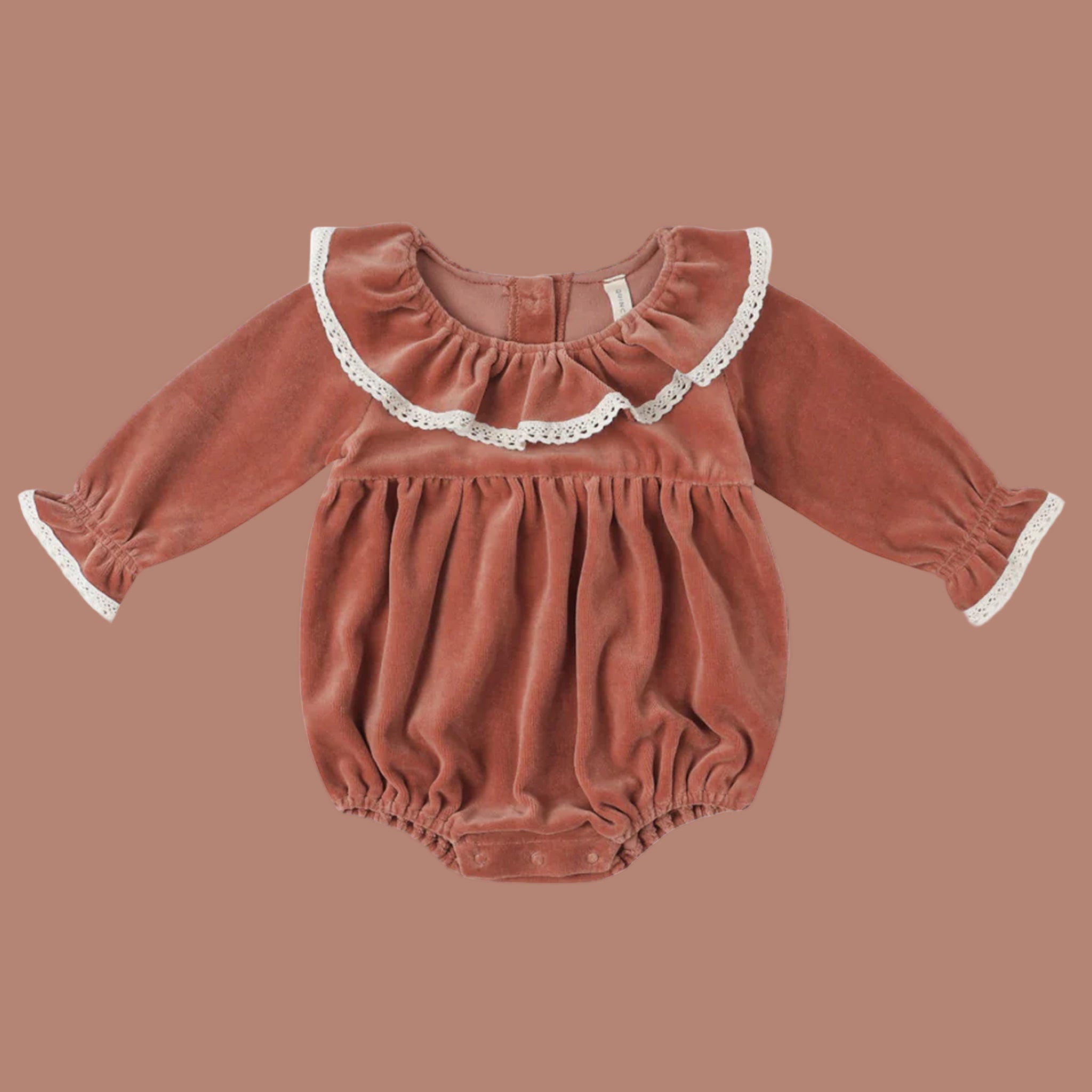 A cranberry colored velvet romper with a white lace ruffle neckline and sleeve. 