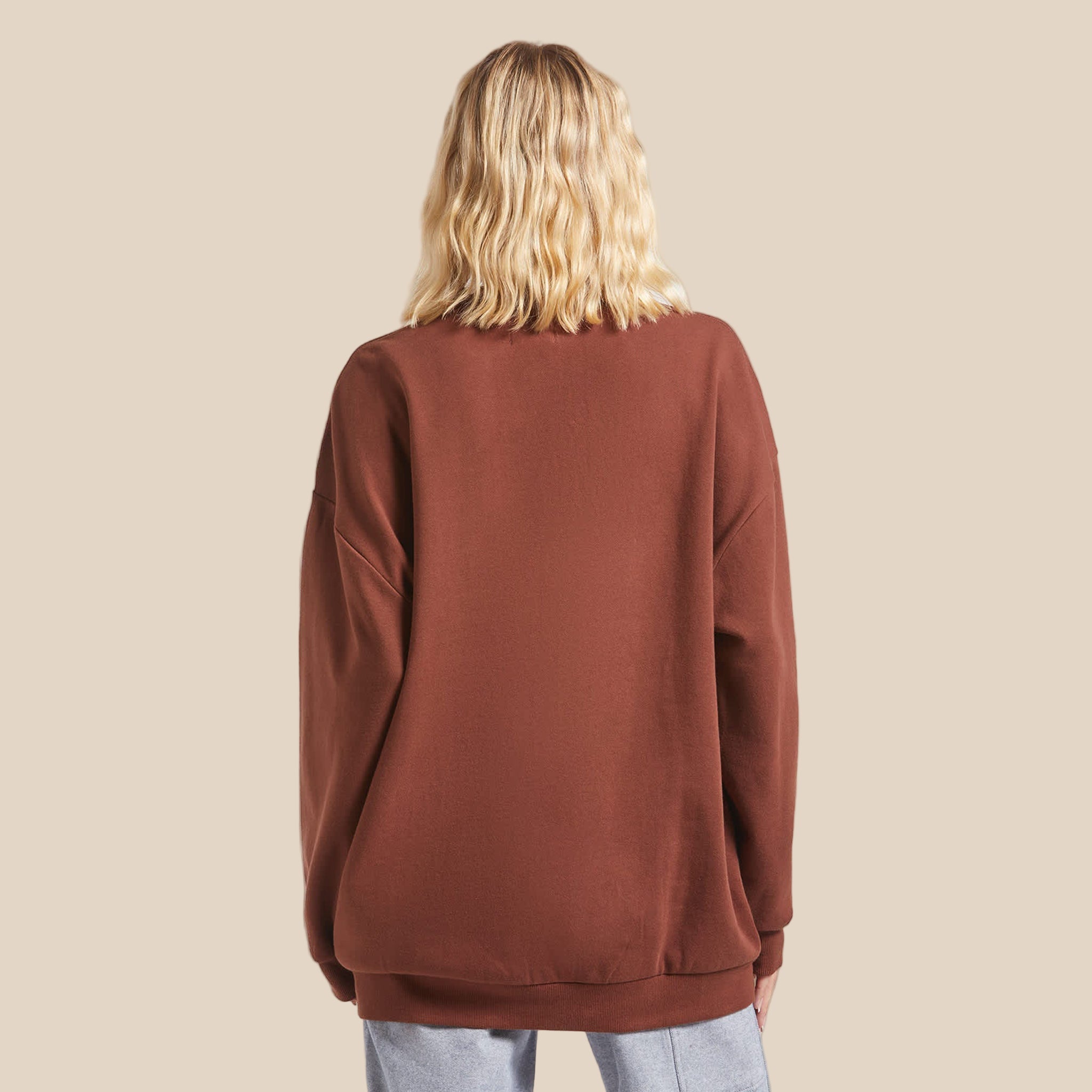 A rust colored crew neck sweatshirt with cream colored text that reads, "Brixton" with a graphic of a cowboy on a bucking horse. 