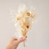 A bouquet of neutral white and tan dried and preserved florals. 
