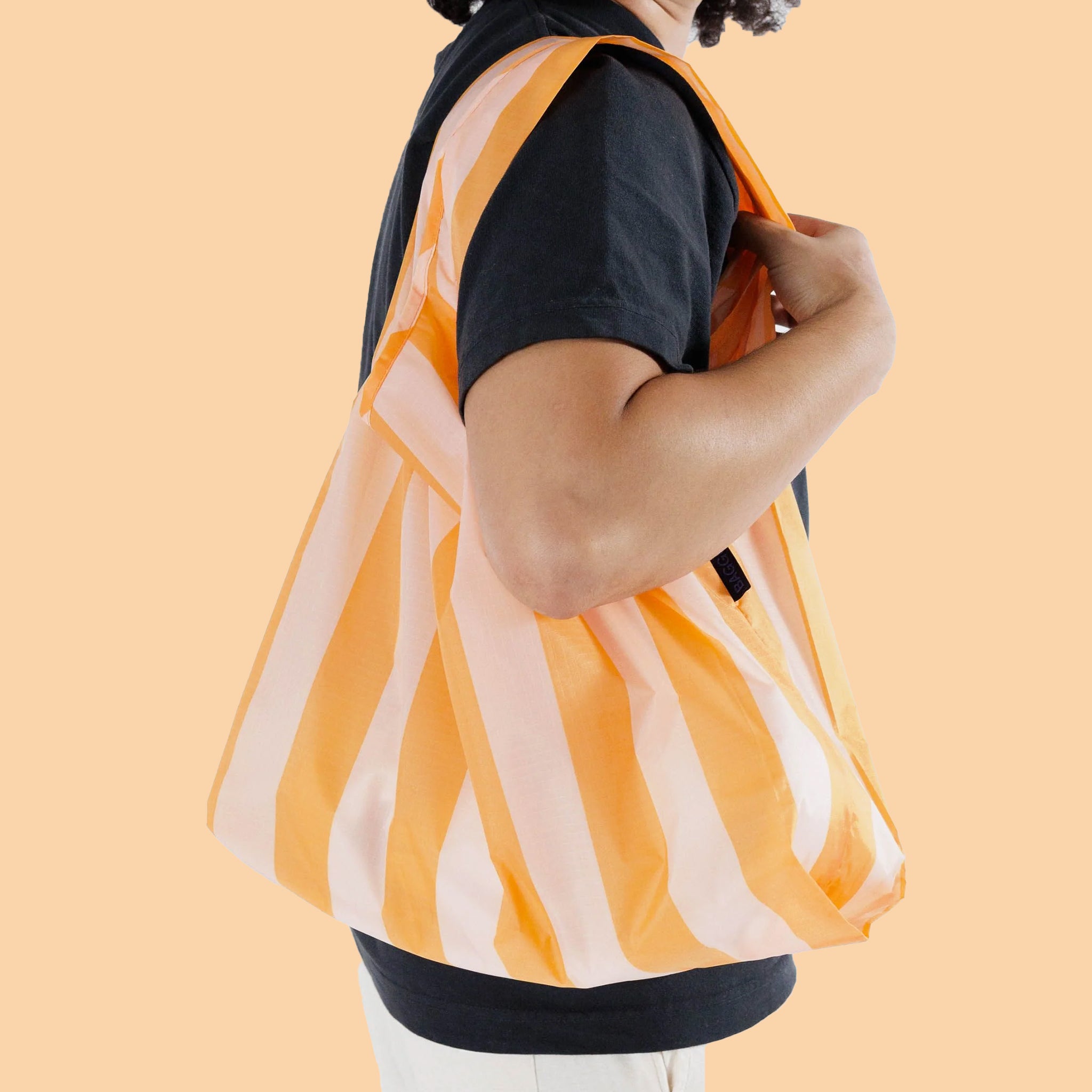 A nylon reusable bag with tangerine wide stripes.