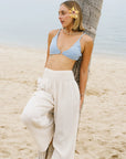 A wide leg pair of cotton pants in a creamy white shade and a stretchy waistband. 