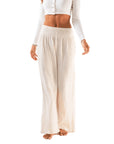 A wide leg pair of cotton pants in a creamy white shade and a stretchy waistband. 