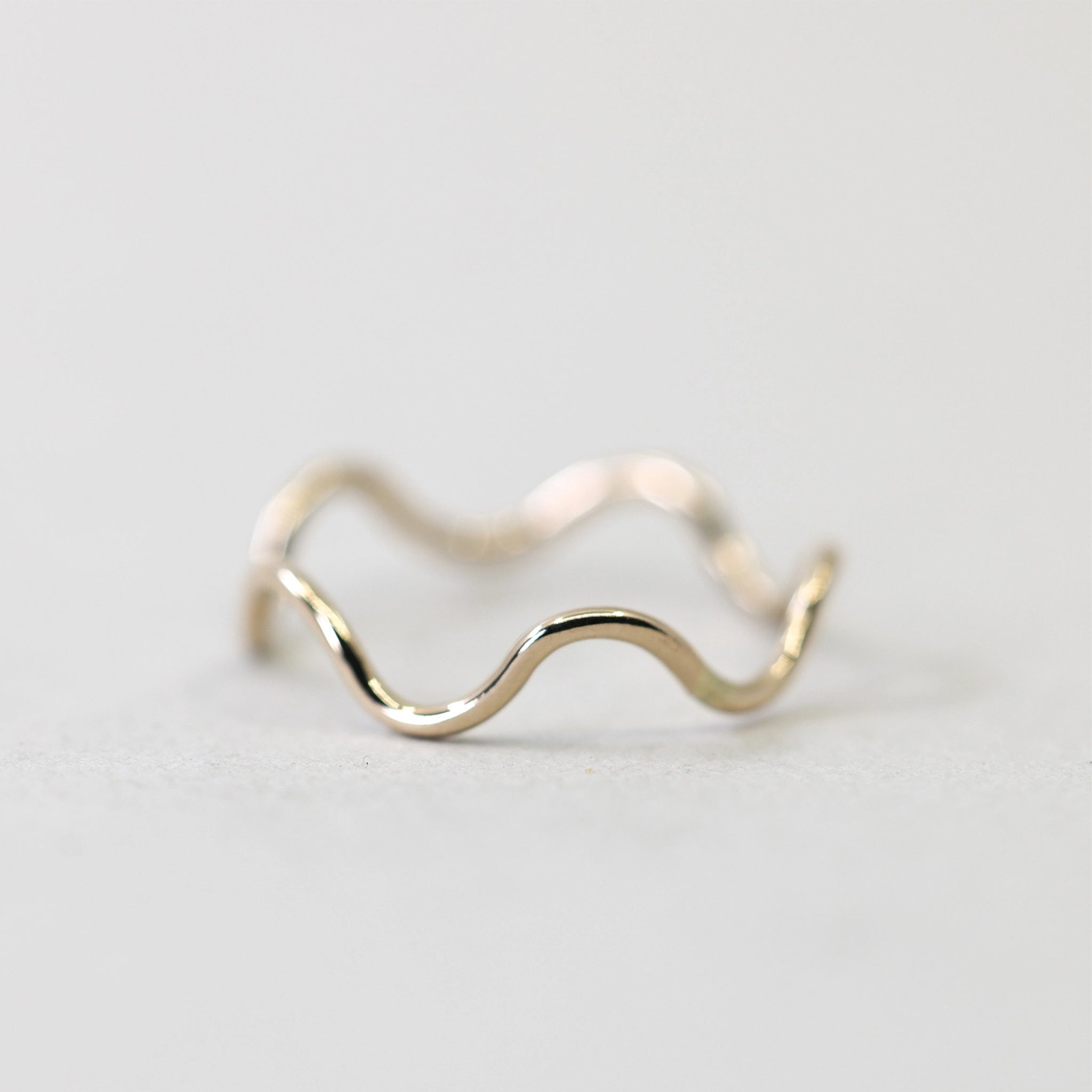 A thin gold wavy ring. 