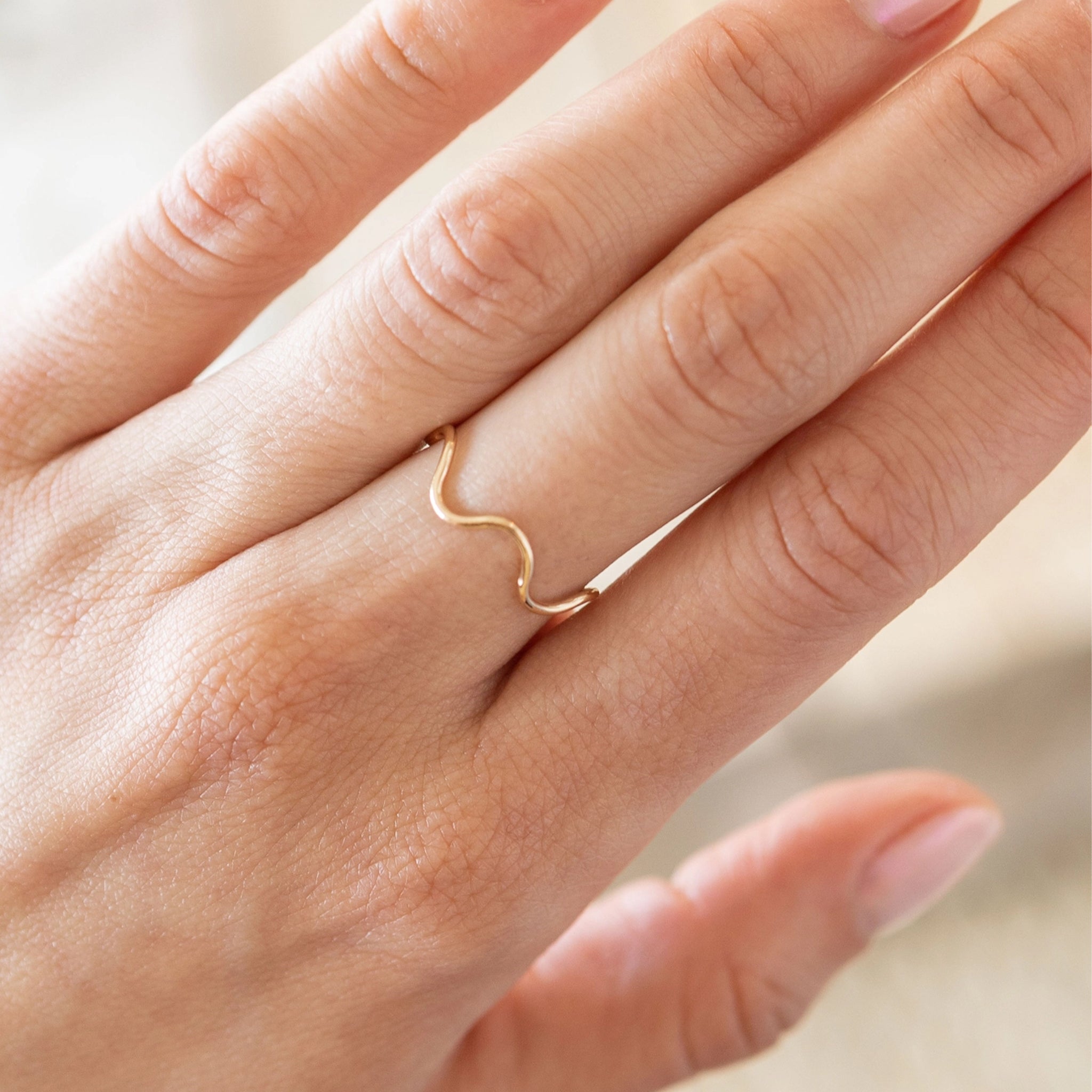 A thin gold wavy ring. 