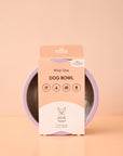 On a peachy background is a lavender dog bowl with a stainless steel interior.