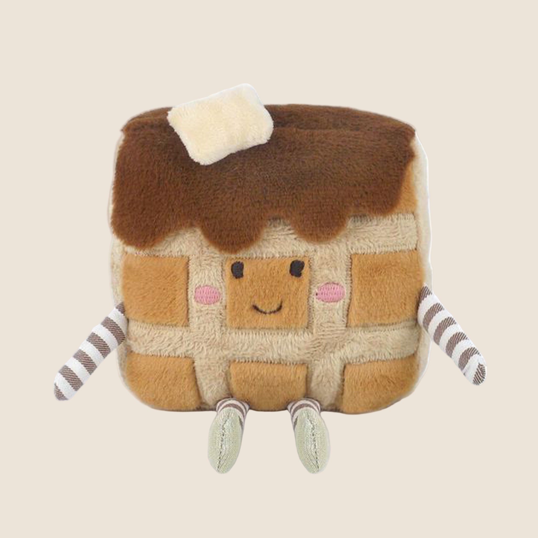 A waffle shaped stuffed toy with striped arms and legs and a smiling face. 
