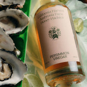 A clear bottle of persimmon vinegar with a white label.