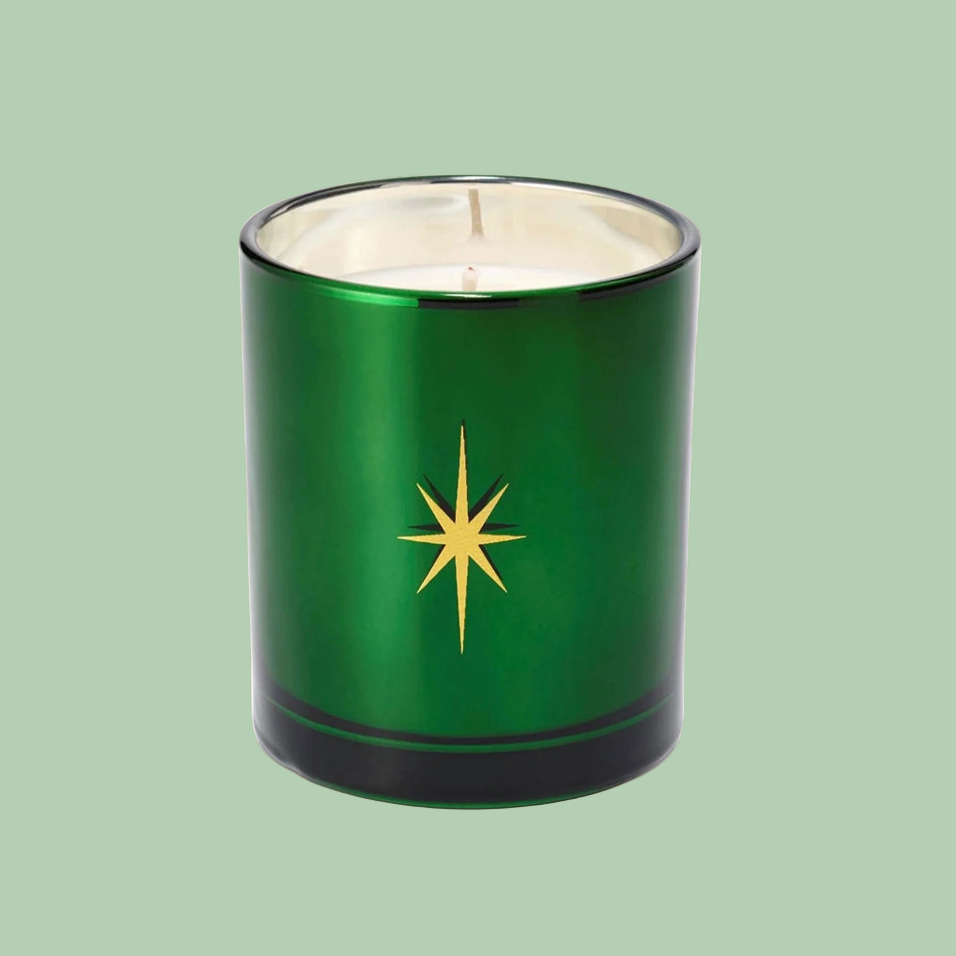 A green glass jar candle with a graphic of a star in the center. 