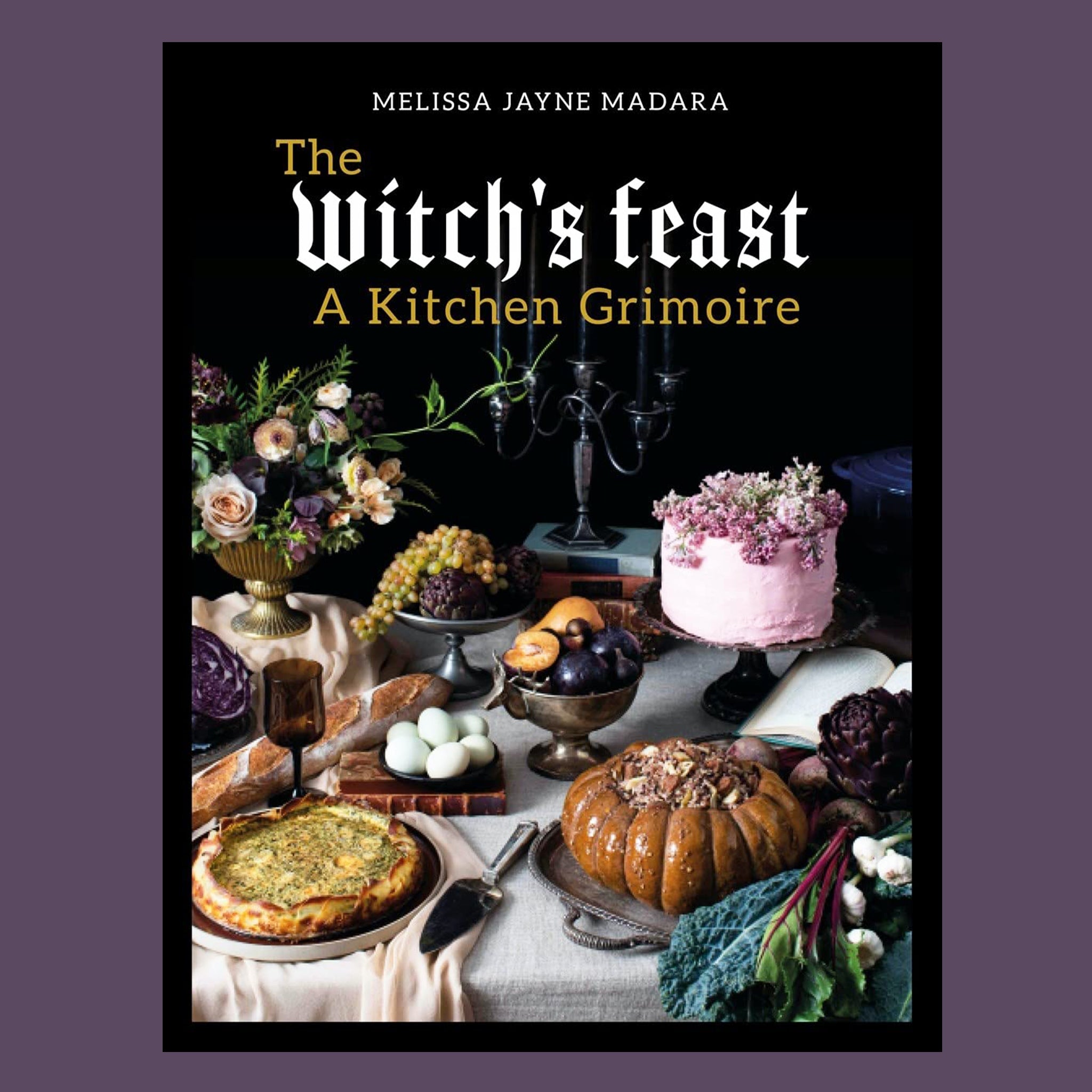 A black book cover with a table scape with spooky treats and text that reads, 'The Witch's Feast A Kitchen Grimoire'. 