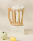 A wooden toy blender with two wooden fruit shaped toys. 